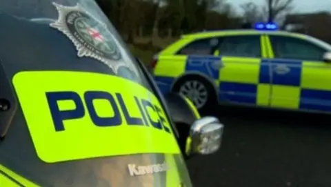 Stationary police vehicles with Police Service emblem