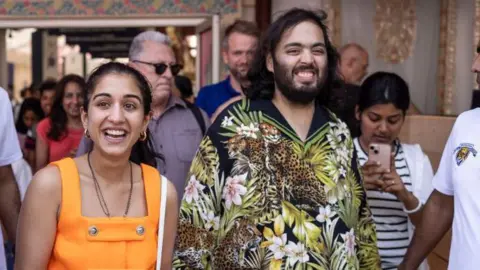 AFP via Getty Images Billionaire tycoon and Chairman of Reliance Industries Mukesh Ambani's son Anant Ambani (R) and his wife Radhika Merchant (C) arrive at the India house as part of the Paris 2024 Olympic Games in Paris, on 30 July 2024