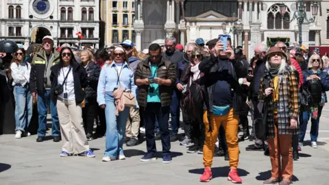 Tourists walk in St Mark's Square 