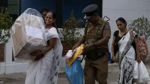 Getty Images Autoridades eleitorais levam uma urna lacrada para um centro de contagem durante a eleição presidencial em Colombo, Sri Lanka, no sábado, 21 de setembro de 2024. 