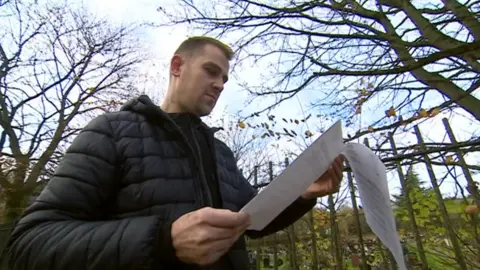 Nathan Wint holding a copy of the letter