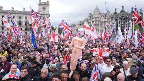 PA Media People take part in Tommy Robinson's Unite the Kingdom march in central London.