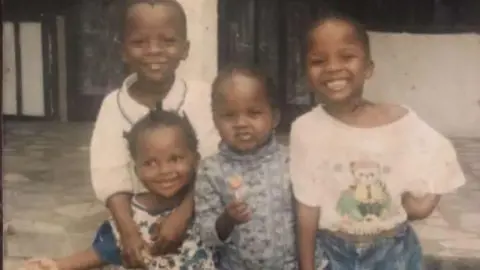 Rosca Onya Family photograph showing four young children standing close together and smiling