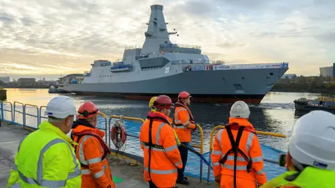 John Linton / BAE Systems qua Bộ Quốc phòng HMS Glasgow đang trên đường đến xưởng đóng tàu Scotstoun sau khi được hạ thủy thành công trên sông Clyde.