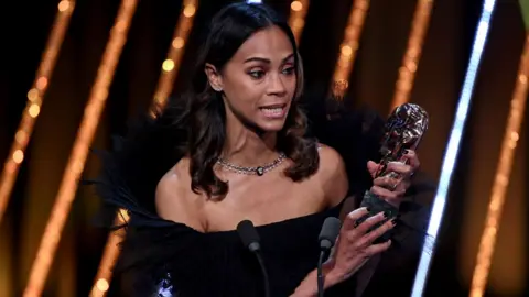 Getty Images Zoe Saldaña accepts the Supporting Actress Award for 'Emilia Pérez' on stage during the EE BAFTA Film Awards 2025 at The Royal Festival Hall on February 16, 2025 in London, England