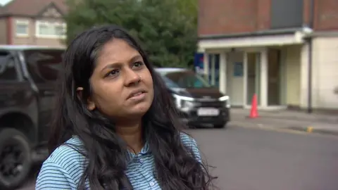 Resident Nitya Sravya Jogi stands outside in a striped shirt