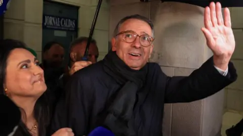 EPA António José Seguro, pictured waving next to his wife Margarida Maldonado Freitas under an umbrella in the rain