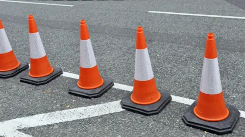 BBC Orange and white traffic cones on a road 