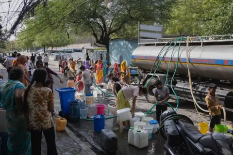 Getty Images Families fill up empty water buckets with potable water from a New Delhi Municipal Council water tanker on May 02, 2024