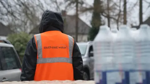 A person in an orange high-visibility jacket. 