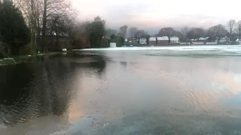The Whalley Range cricket pitch fully covered by floodwater