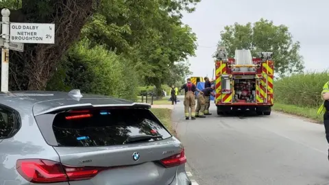 Emergency services at the scene of a crash on a rural road
