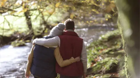 Getty Images Couple walking by a river