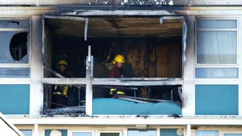 Firefighters inside a burnt out flat in the Lakanal House tower block in 2009