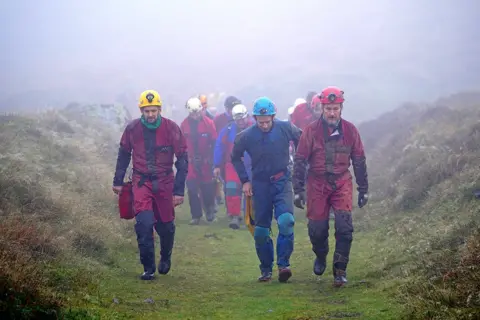 PA Media Rescuers assemble near the Ogof Ffynnon Ddu caves, 8 November 2021