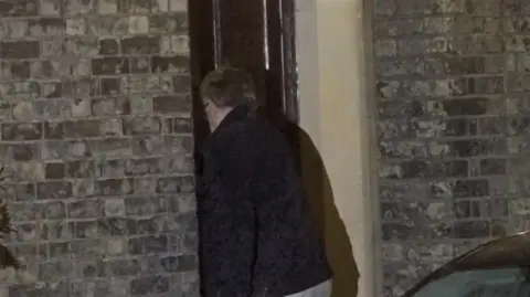 The back of Peter Mandelson as he enters the front door of his house.