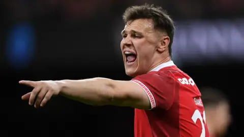 Jarrod Evans points while playing for Wales