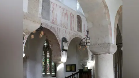 Hilary Rule/Ickleton Church The interior of St Mary Magadalen Church Ickleton, Cambrideshire. The lower half shows the wooden pews above are white arches with faded medieval frescoes. 