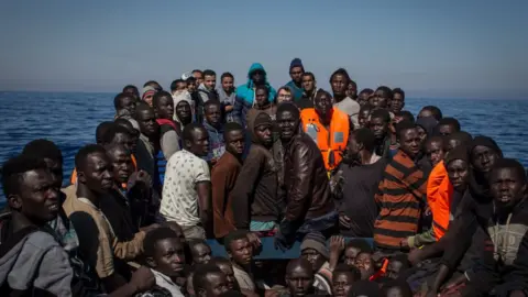 Getty Images Migrants afloat in the Mediterranean wait to be rescued by Italian authorities.