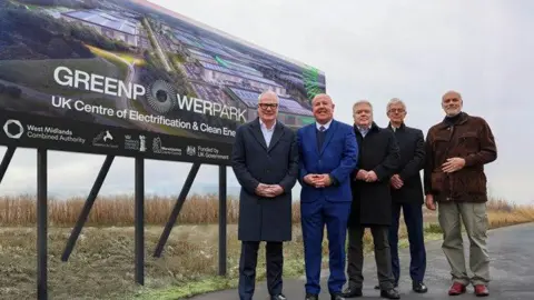 WMCA Four men in suits stood infront of a billboard 