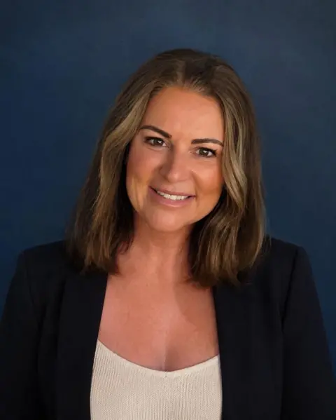 Restore Britain Restore Britain candidate, Rebecca Shepherd. She has shoulder-length dark hair, is wearing a dark blazer and a white blouse. 
