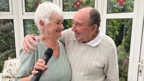 Barbara and Ken James looking at each other and singing