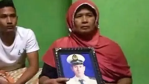 BBC Indonesia Afrida holding photo of her son at her home in Padang Sumatra