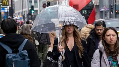 Getty Images Woman holding an umbrella on Oxford Street