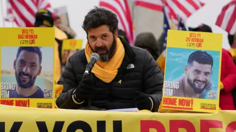 Reuters Liran Berman, brother of hostages Gali and Ziv Berman held by Hamas in Gaza, speaks during a news conference in Washington DC in January on the eve of Donald Trump's inauguration. There are posters with photos of his brothers Gali and Ziv to his left and right