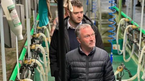 Shadow Environment Secretary Steve Reed in milking parlour in Stocksfield