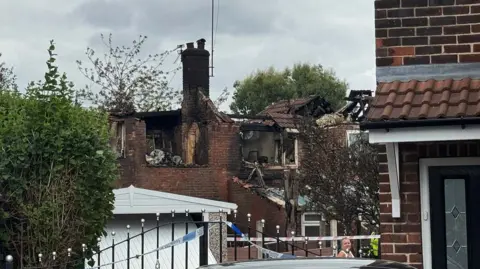 A photo of the blackened back of the house with substantial fire damage