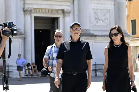 Getty Images US tech entrepreneur Bill Gates and partner Paula Hurd in Venice, Italy, for the wedding of Jeff Bezos and Lauren Sanchez. Both are wearing black outfits. 