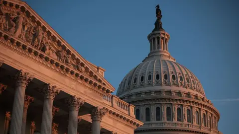 An exterior of the US Capitol with morning light hitting the exterior