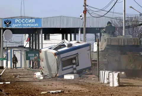 TASS / Getty Images A security booth knocked over at the Perekop checkpoint, connecting the Crimean peninsula to the Ukrainian mainland