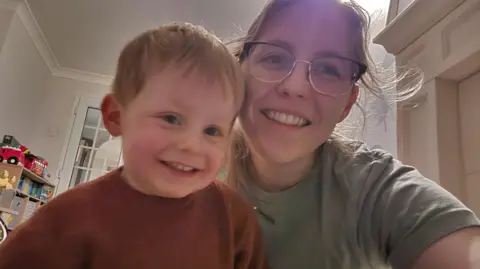 Rebekah Beswick A toddler boy and his mum smile as they have a selfie for the camera 