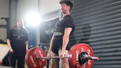 WHITE LIGHTS MEDIA Hayden Simmons lifts a bar with weights on either side