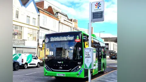 A Leicester Buses vehicle parked at a real-time information bus totem.