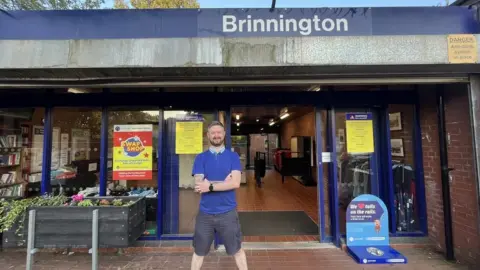 BBC Stewart Hall standing in front of Brinnington station