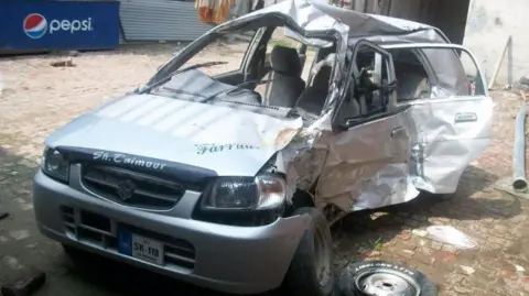 Image shows the mangled wreckage of a silver care that has been involved in a crash