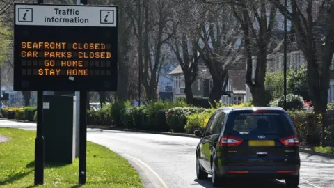 BEN STANSALL/AFP via Getty Images Drivers in Southend are told to go home by a sign