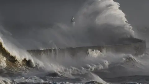 Dramatic waves crash on the breakwater at Newhaven Harbour in East Sussex