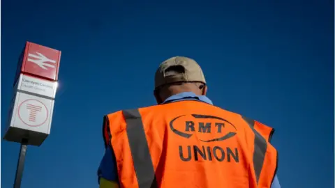 Getty Images Man in a RMT union hi-vis jacket at Cardiff Central station