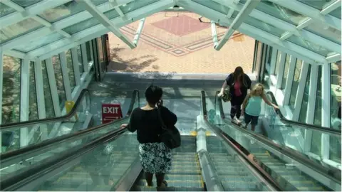 A woman on an escalator