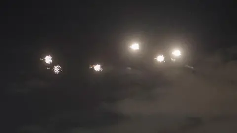 Explosions are seen in the dark sky over Kyiv