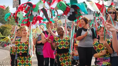 BBC Children and adults in colourful costume walking down St Stephens Street in Norwich during Lord Mayor's Procession in 2011