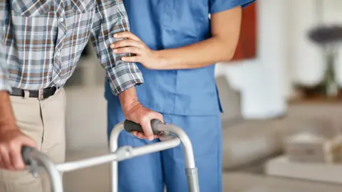 Getty Images/shapecharge Carer with elderly man