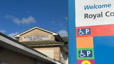 BBC A brick building with a pitched roof and 'Royal Cornwall Hospital' in blue lettering