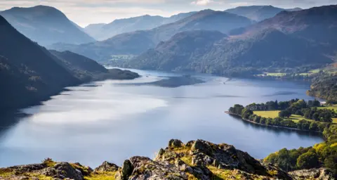 Andrew Locking A general view of Ullswater in the Lake District. It is looking down on the lake with a vista of interlinking mountain peaks stretching into the distance.