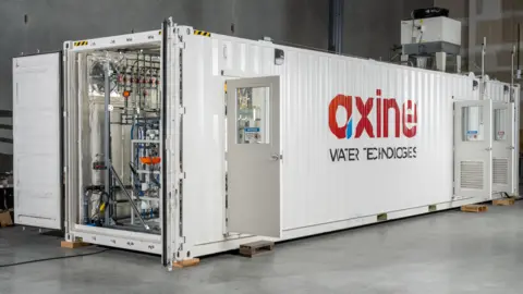 Axine Water Technologies A white container with the doors open - inside you can see some of the Axine water cleaning tech.