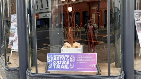 Su Devine/Dale Hardy A shop window with a poster for Sunderland Arts and Culture Trail 
